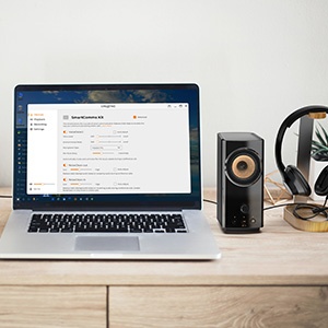 laptop on a desk with smartcomms kit's software screen, t60 sitting beside the laptop with headset