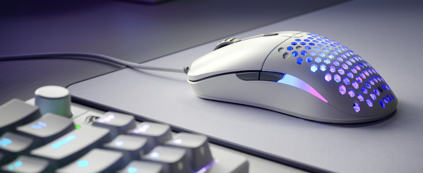 Spelopstelling met RGB-verlichte gamingmuis en -toetsenbord op een donker oppervlak met een gedeeltelijke laptop zichtbaar.