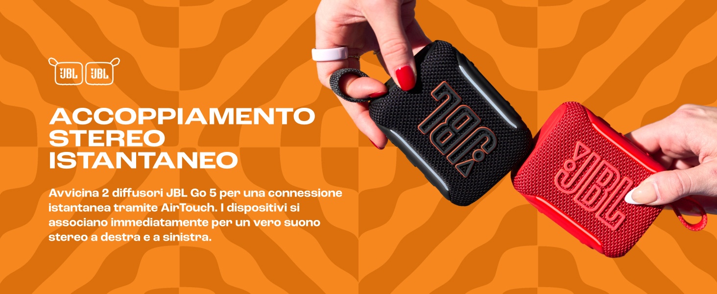 Il testo recita «ACOPLAMIENTO STEREO INSTANTANEO». Sfondo arancione con mani che reggono altoparlanti portatili neri e rosa che dimostrano la capacità di accoppiamento stereo istantaneo.