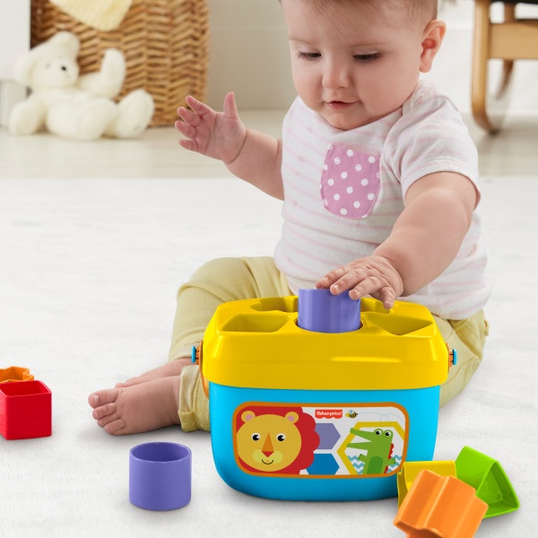 Colorful children's sorting toy set with yellow container base and various shaped blocks being played with.