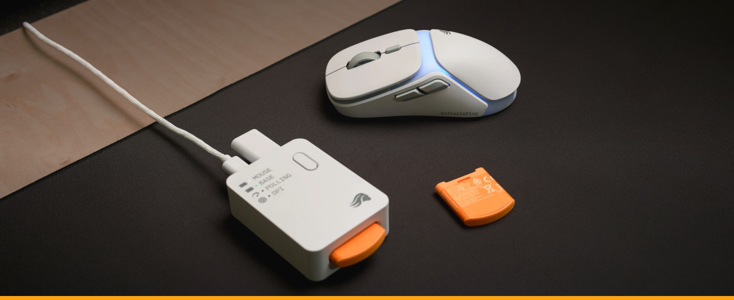 Station de recharge USB blanche avec détails en orange, connectée à une souris d'ordinateur sans fil sur une surface de bureau noire.