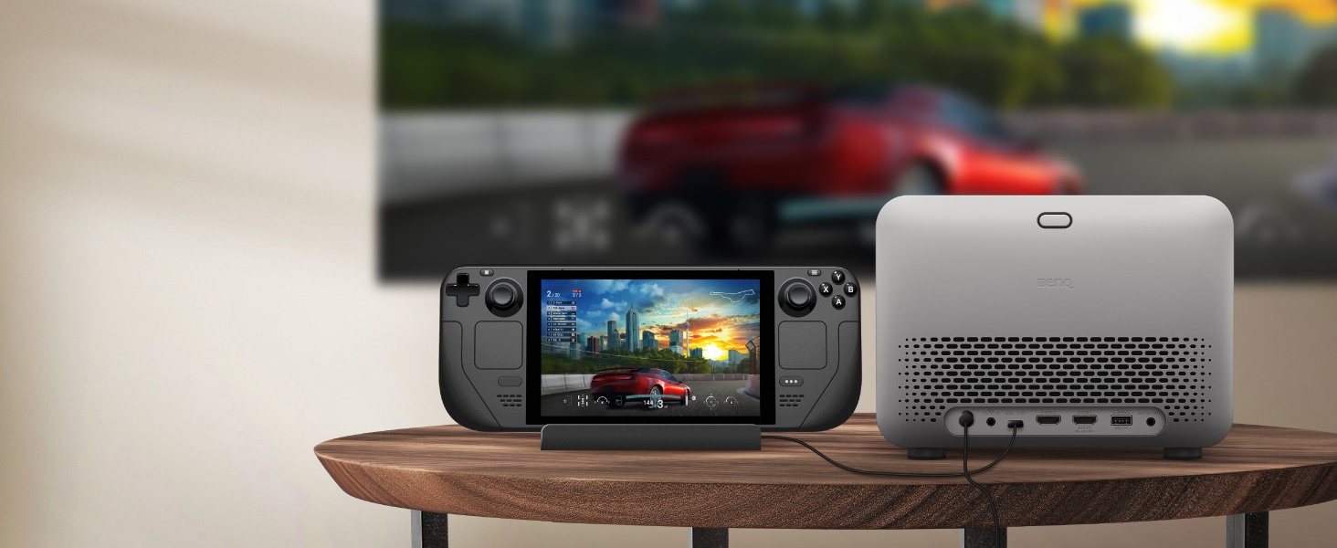 Dispositifs de jeu portatifs et appareils électroniques exposés sur une surface en bois, montrant un système de jeu portable avec écran et ce qui semble être un équipement auxiliaire.